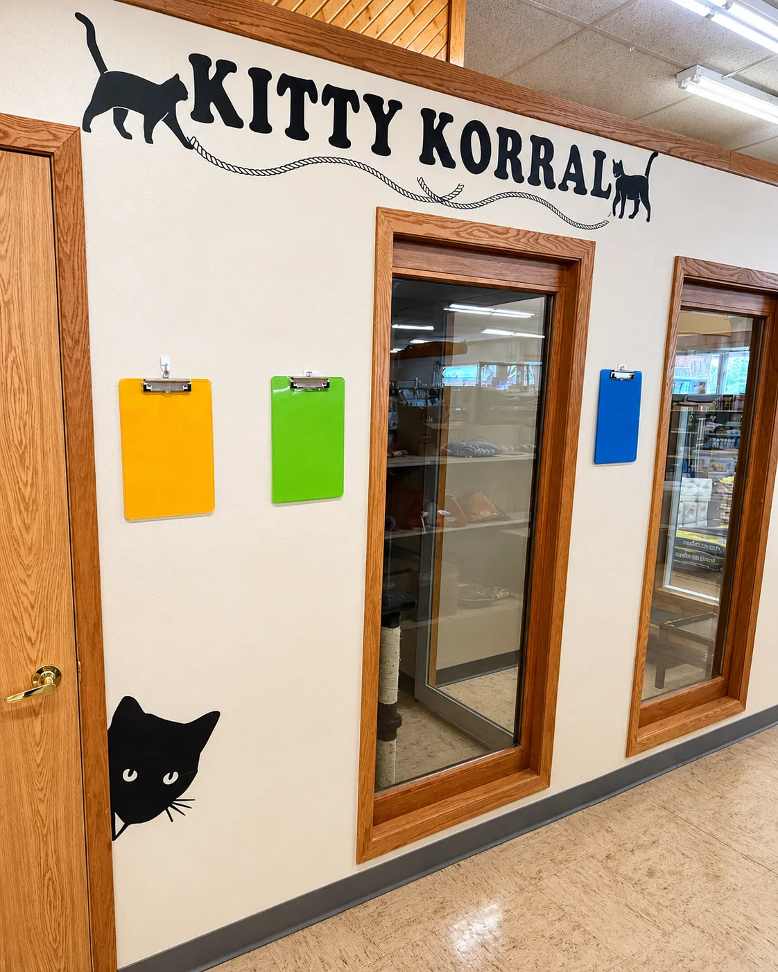 The hand-painted Kitty Korral wall sign with a black cat