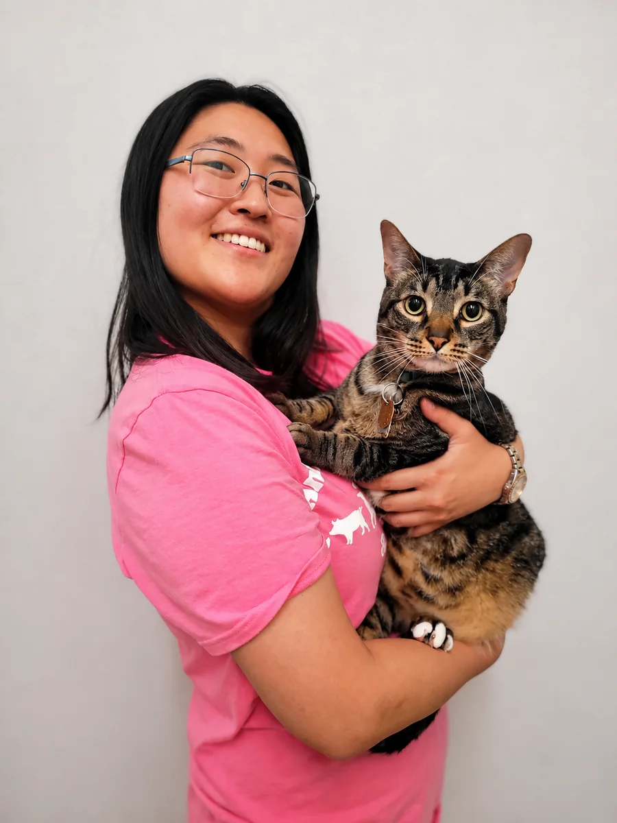Esther, Sales and Kennel Assistant, holding boarding cat Maverick