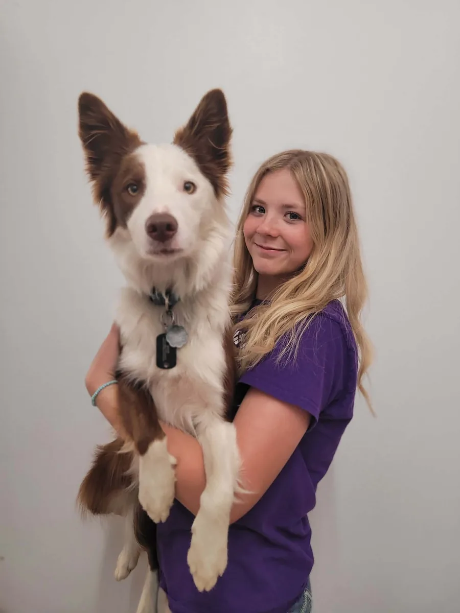 Jenna, Sales and Kennel Assistant, holding her dog Callie