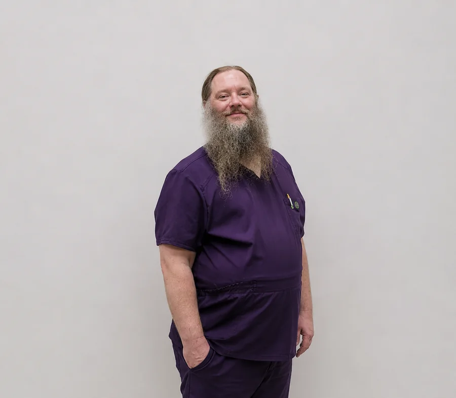 Jason Murphy, Veterinary Assistant, in purple scrubs
